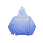 A light blue pullover hoodie shown from the back, featuring a yellow graphic print that reads 'Midnight Super Life Lessons' across the upper back, set against a plain white background.
