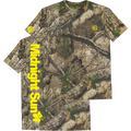 A short-sleeve t-shirt with an all-over woodland camouflage pattern, featuring a large vertical yellow 'Midnight Sun' text graphic on the right sleeve and a small yellow circular logo on the left chest and right shoulder.